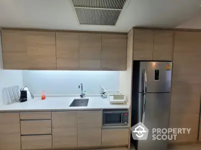 Modern kitchen with sleek cabinetry and stainless steel fridge