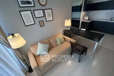 Modern living room with cozy sofa and stylish kitchen in open layout apartment.