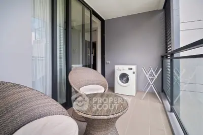 Modern balcony with stylish wicker chairs and washing machine, perfect for urban living.