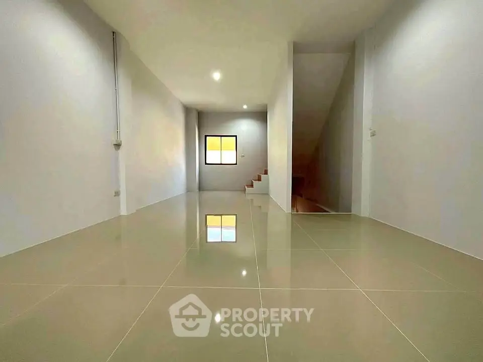 Spacious modern interior with glossy tiled floors and staircase, ideal for customization.