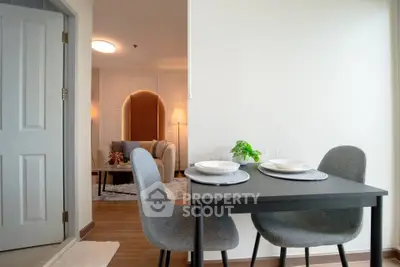 Modern dining area with stylish table and chairs, leading to a cozy living room with elegant decor.