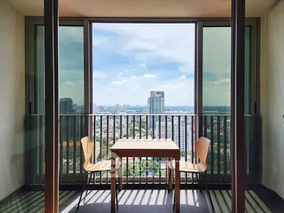 Stunning city view from a modern balcony with elegant seating, perfect for relaxation.