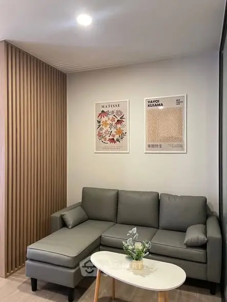 Modern living room with stylish gray sofa and decorative wall art