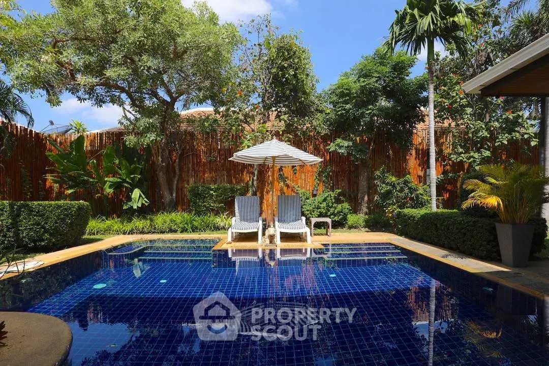 Luxurious outdoor pool area with lush greenery and sun loungers, perfect for relaxation and leisure.