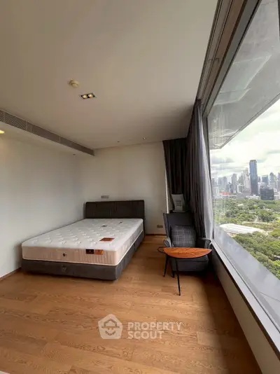Spacious bedroom with stunning city view and modern furnishings.