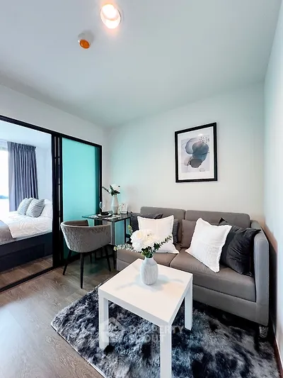 Modern living room with cozy decor and stylish furniture in a compact apartment setting.