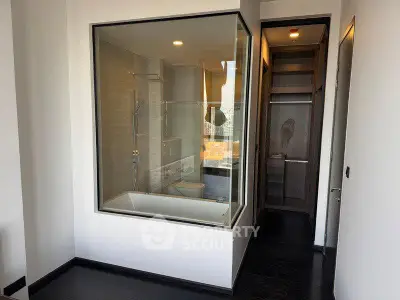 Modern bathroom with glass enclosure and sleek design in luxury apartment.