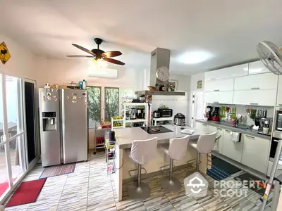 Spacious kitchen with modern appliances, ample countertop space, and a cozy dining area that opens up to a sunlit balcony.