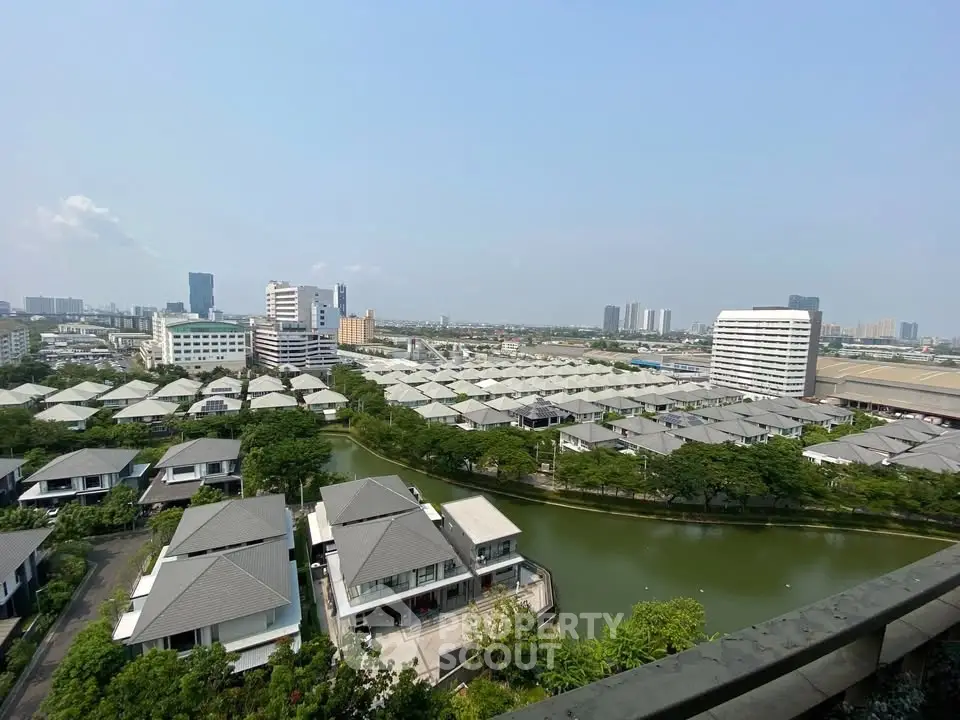 Stunning aerial view of modern residential complex with lush greenery and serene water features.