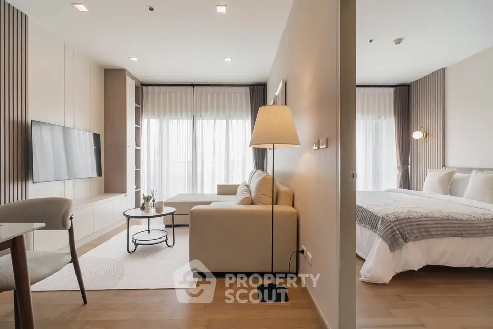 Modern open-plan living room and bedroom with elegant decor and natural light.