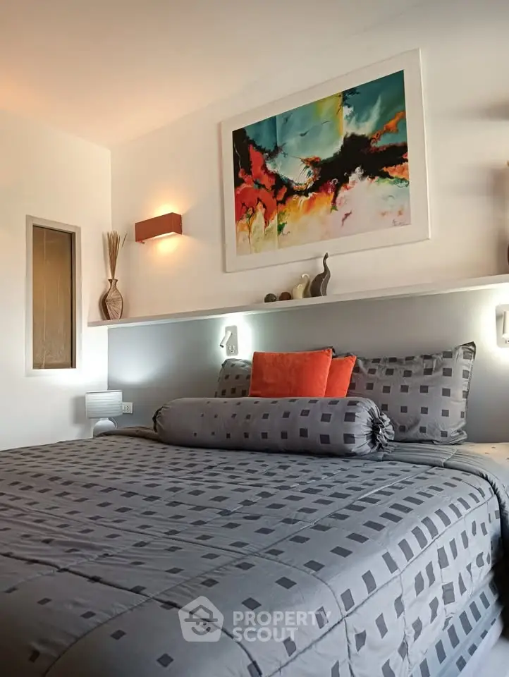 Stylish bedroom with modern art and cozy bedding in a contemporary home.