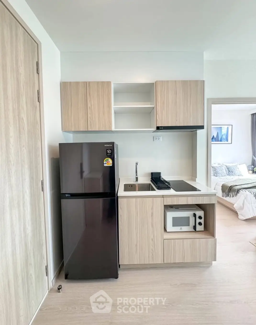 Modern compact kitchen with sleek appliances and light wood cabinetry