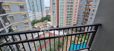 Stunning cityscape view from high-rise balcony overlooking pool and tennis court.