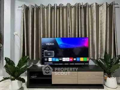 Modern living room with sleek TV setup and elegant curtains, perfect for entertainment and relaxation.