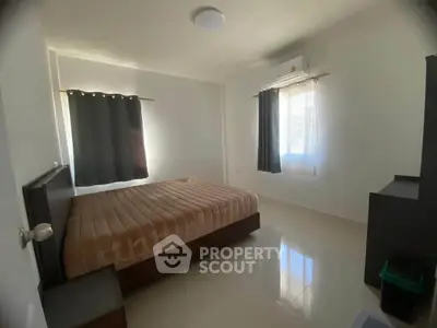 Spacious bedroom with natural light and modern furnishings