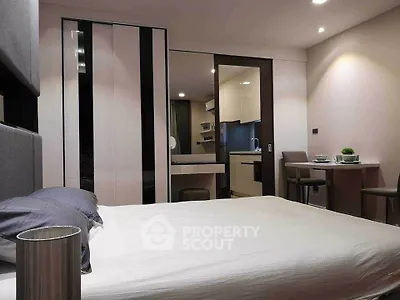 Modern bedroom with sleek design and adjacent kitchen area, perfect for urban living.