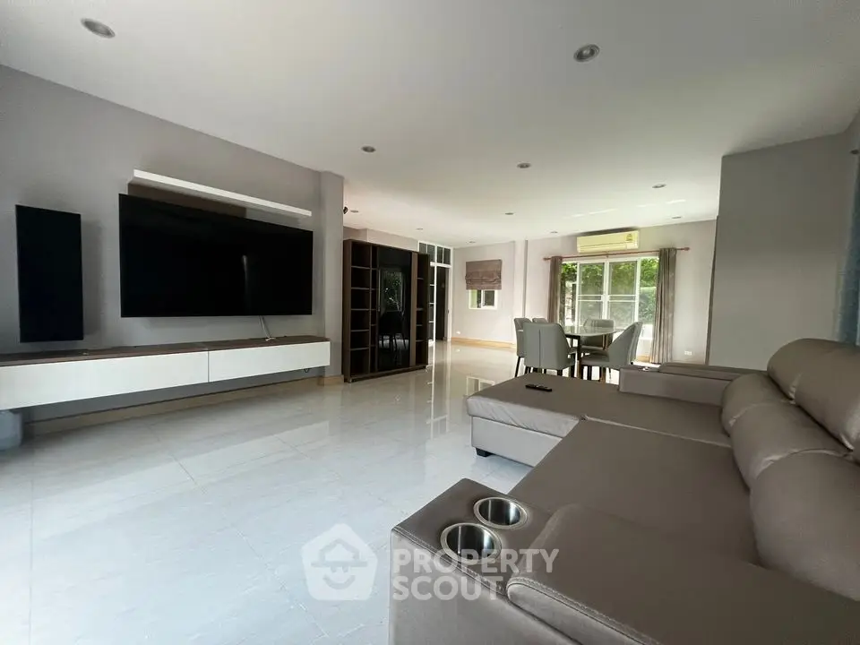 Spacious modern living room with large TV and comfortable seating