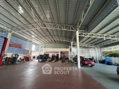 Spacious industrial garage with high ceilings and multiple vehicle service bays.