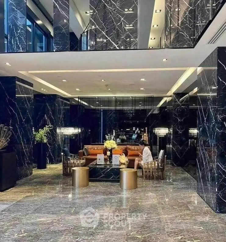 Luxurious marble lobby with elegant seating and modern lighting in a high-end building.