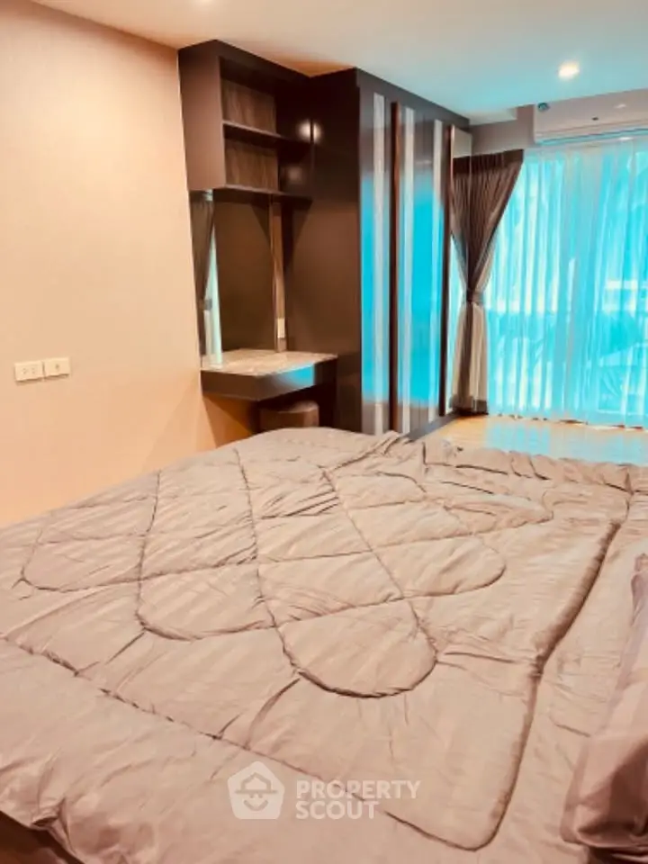 Modern bedroom with large window and stylish decor in a contemporary apartment.