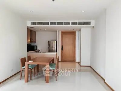 Modern dining area with wooden furniture and sleek kitchen in open layout apartment.