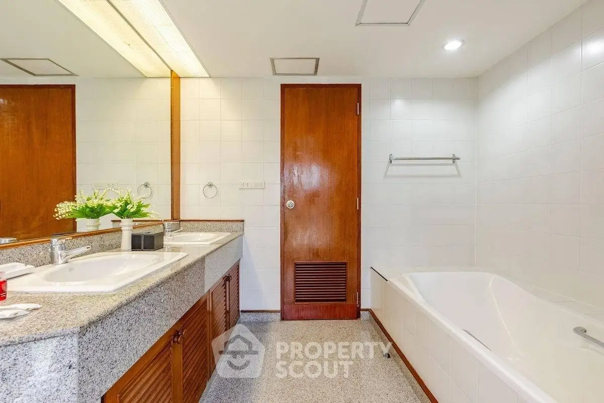 Spacious bathroom with dual sinks and bathtub in modern home