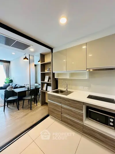 Modern open-layout kitchen with sleek cabinetry and integrated appliances in a stylish apartment.