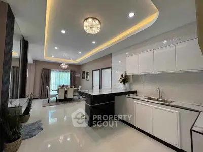 Luxurious open-layout kitchen and dining area with modern lighting and sleek design.
