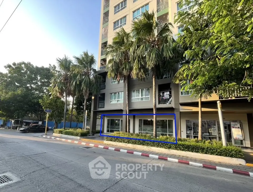 Modern urban building exterior with lush greenery and palm trees, showcasing a vibrant city lifestyle.