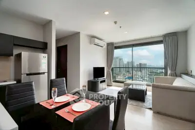 Modern open-plan living room with city view balcony, sleek dining area, and stylish decor.