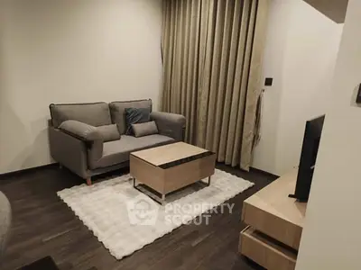 Cozy living room with modern sofa, stylish coffee table, and elegant curtains in a chic apartment.