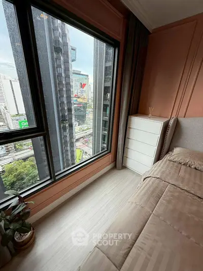 Modern bedroom with city view, large window, and stylish decor in urban apartment.