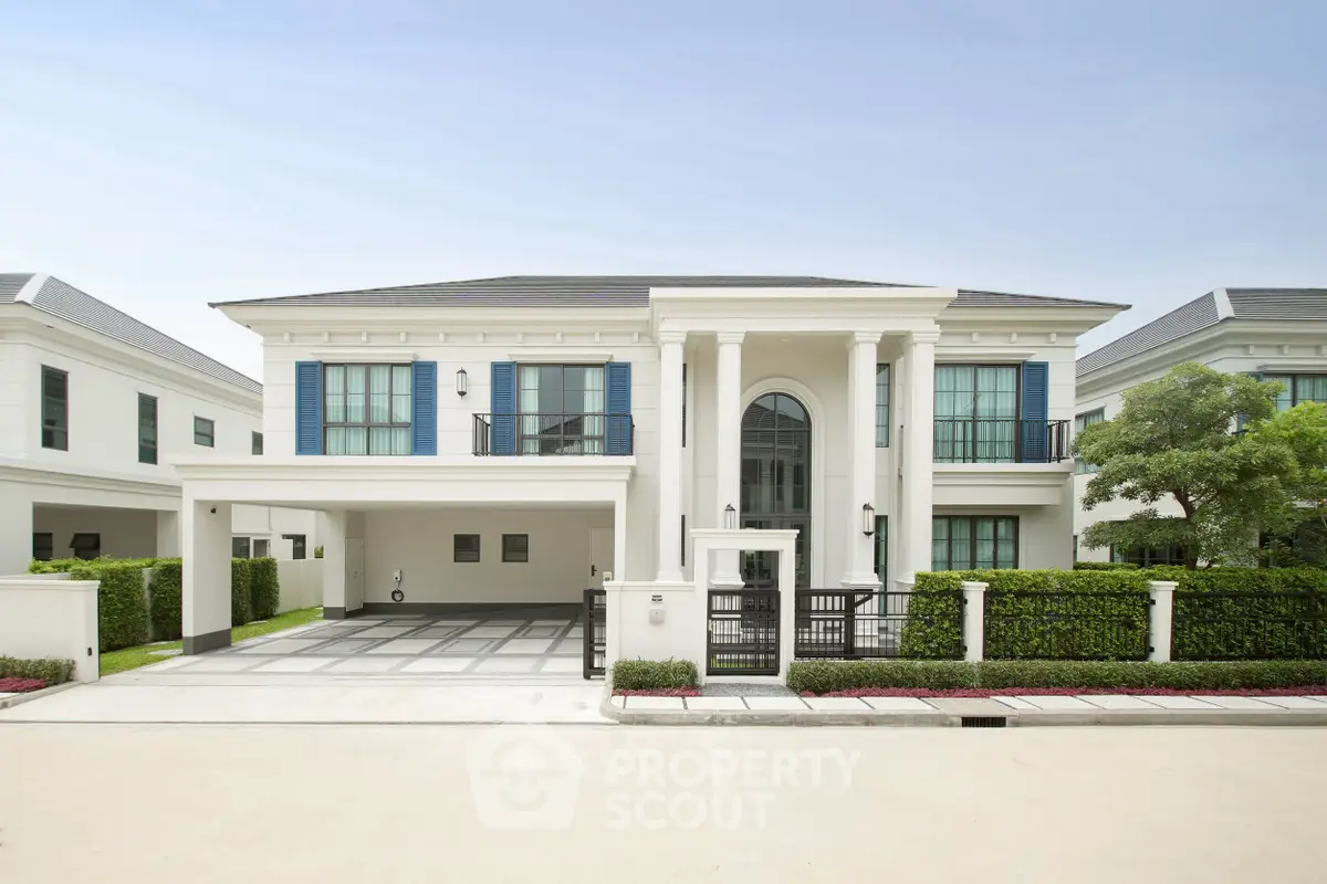 Luxurious modern mansion with grand entrance and spacious driveway in upscale neighborhood.