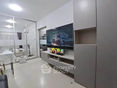 Modern living room with sleek furniture and large TV, perfect for relaxation and entertainment.