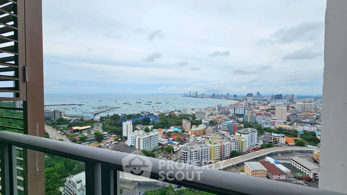 Stunning cityscape and ocean view from high-rise balcony, perfect for urban living.