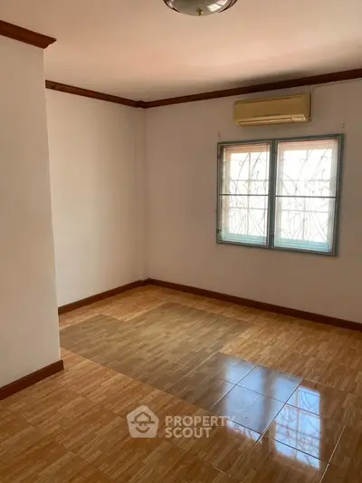 Spacious empty room with tiled flooring and air conditioning, perfect for customization.