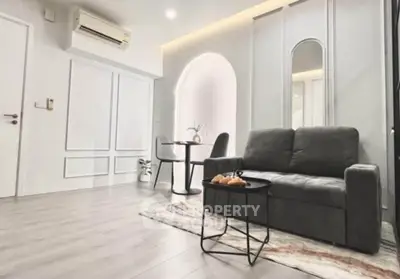 Modern living room with sleek design, featuring a cozy sofa, stylish table, and elegant lighting.
