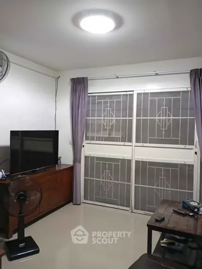 Cozy living room with modern furniture and large window, perfect for relaxation.