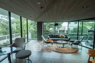 Spacious modern living room with large windows and garden view, perfect for relaxation and entertaining.
