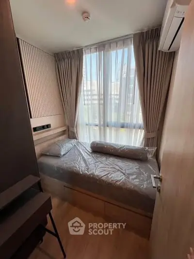 Cozy bedroom with large window and modern decor in a stylish apartment.