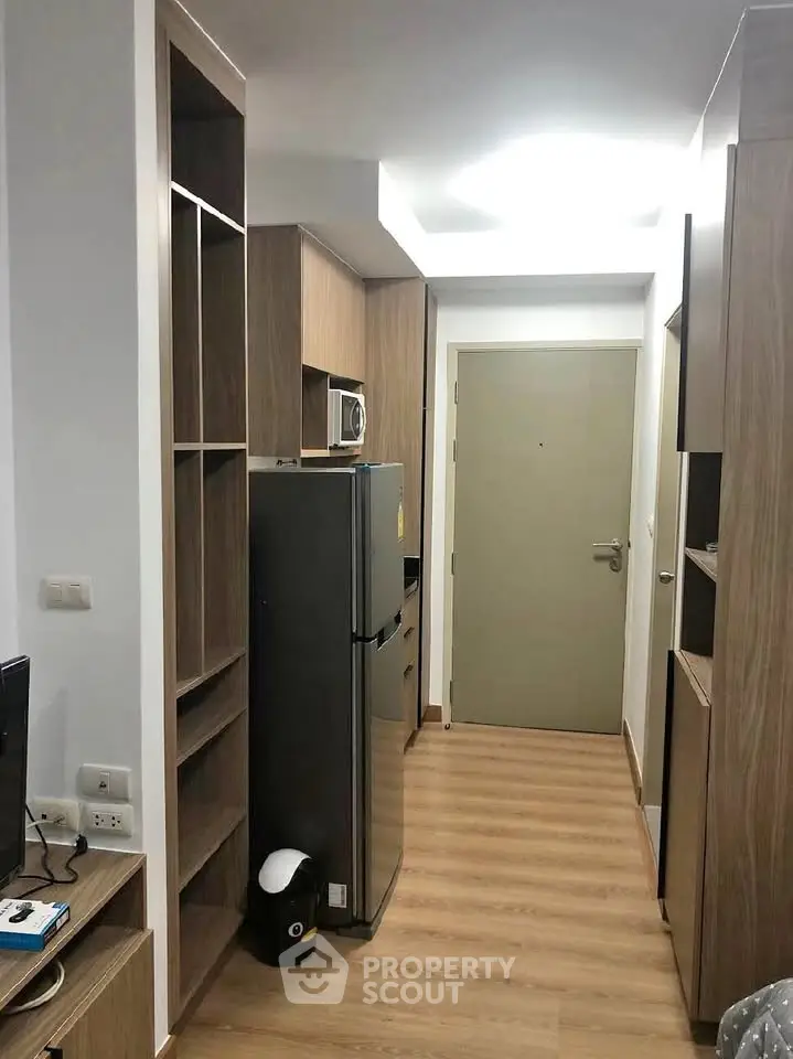 Modern apartment hallway with wooden flooring and built-in storage