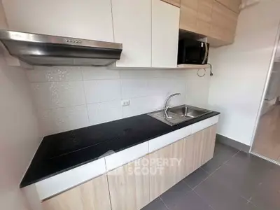 Modern kitchen with sleek cabinetry and built-in appliances in a contemporary apartment.