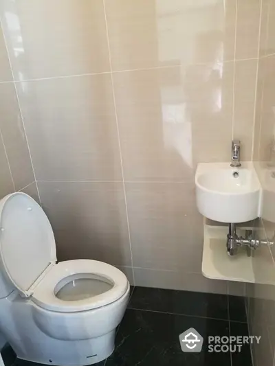 Modern bathroom with sleek toilet and compact wall-mounted sink