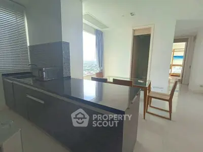 Modern kitchen with sleek countertops and dining area with city view