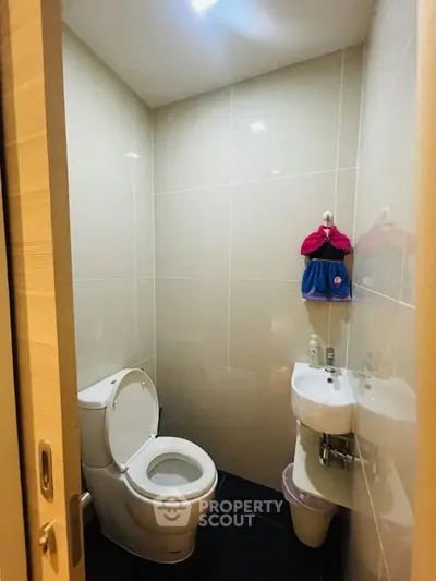 Compact modern bathroom with sleek fixtures and minimalist design.