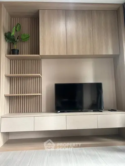 Modern living room with sleek wooden entertainment unit and flat-screen TV