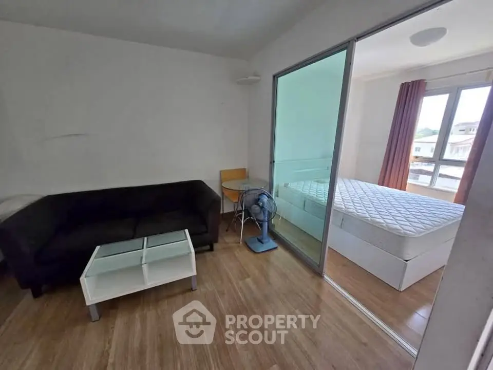 Cozy apartment with living room and bedroom separated by glass sliding door.