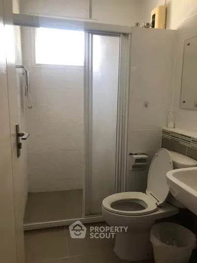 Modern bathroom with sliding glass shower door and white fixtures