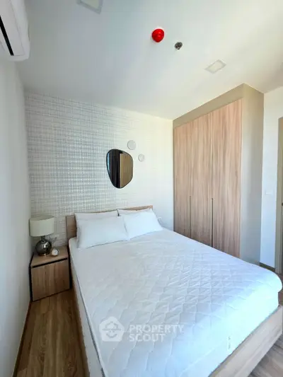 Modern bedroom with stylish decor and ample natural light, featuring a cozy bed and sleek wardrobe.