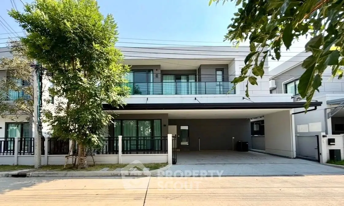 Modern two-story house with spacious driveway and lush greenery in a serene neighborhood.